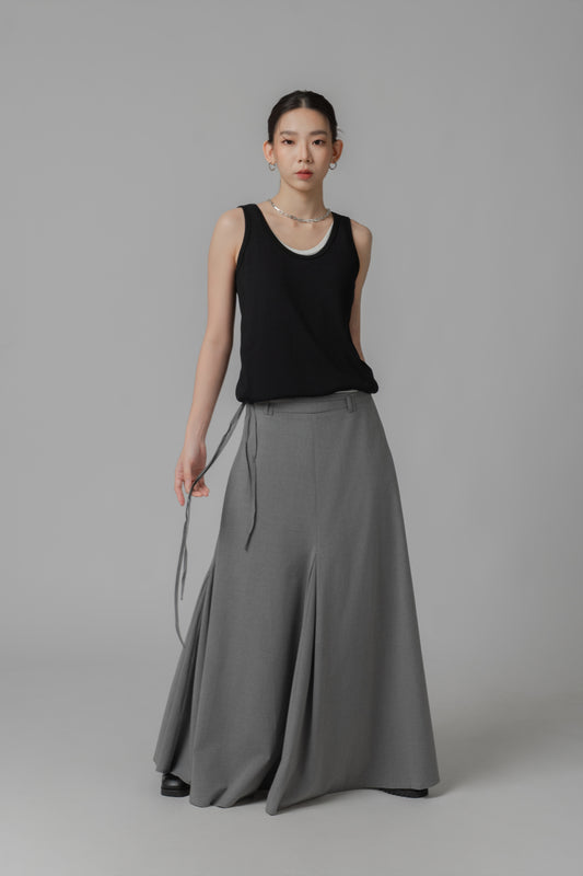 Woman wearing a black two-layer sleeveless top and gray skirt