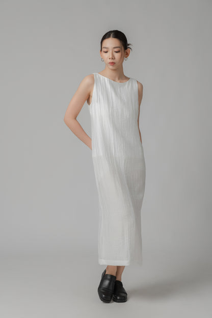 Woman showing the back of a white sleeveless crinkled column dress 